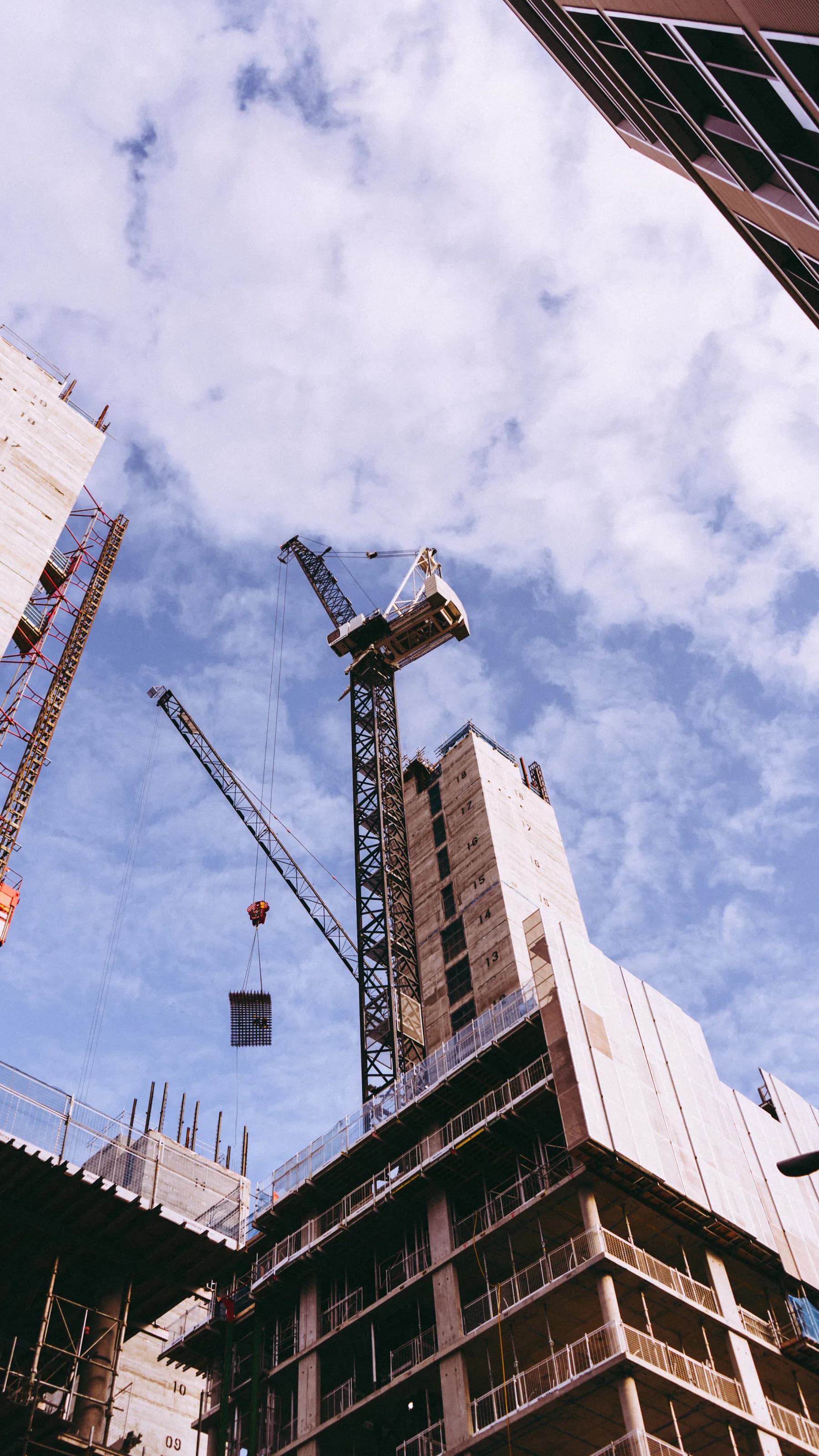 Crane lifting materials above a high-rise construction site